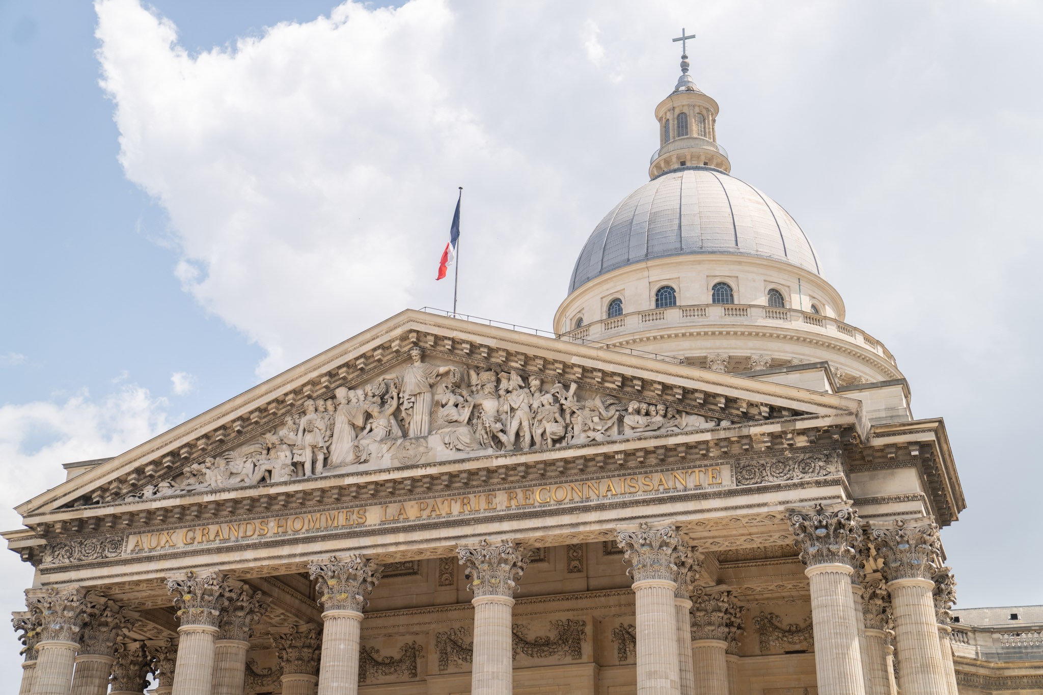 Vue du fronton en pierre de l'assemblée nationale avec les lettres dorées AUX GRANDS HOMMES LA PATRIE RECONNAISSANTE
