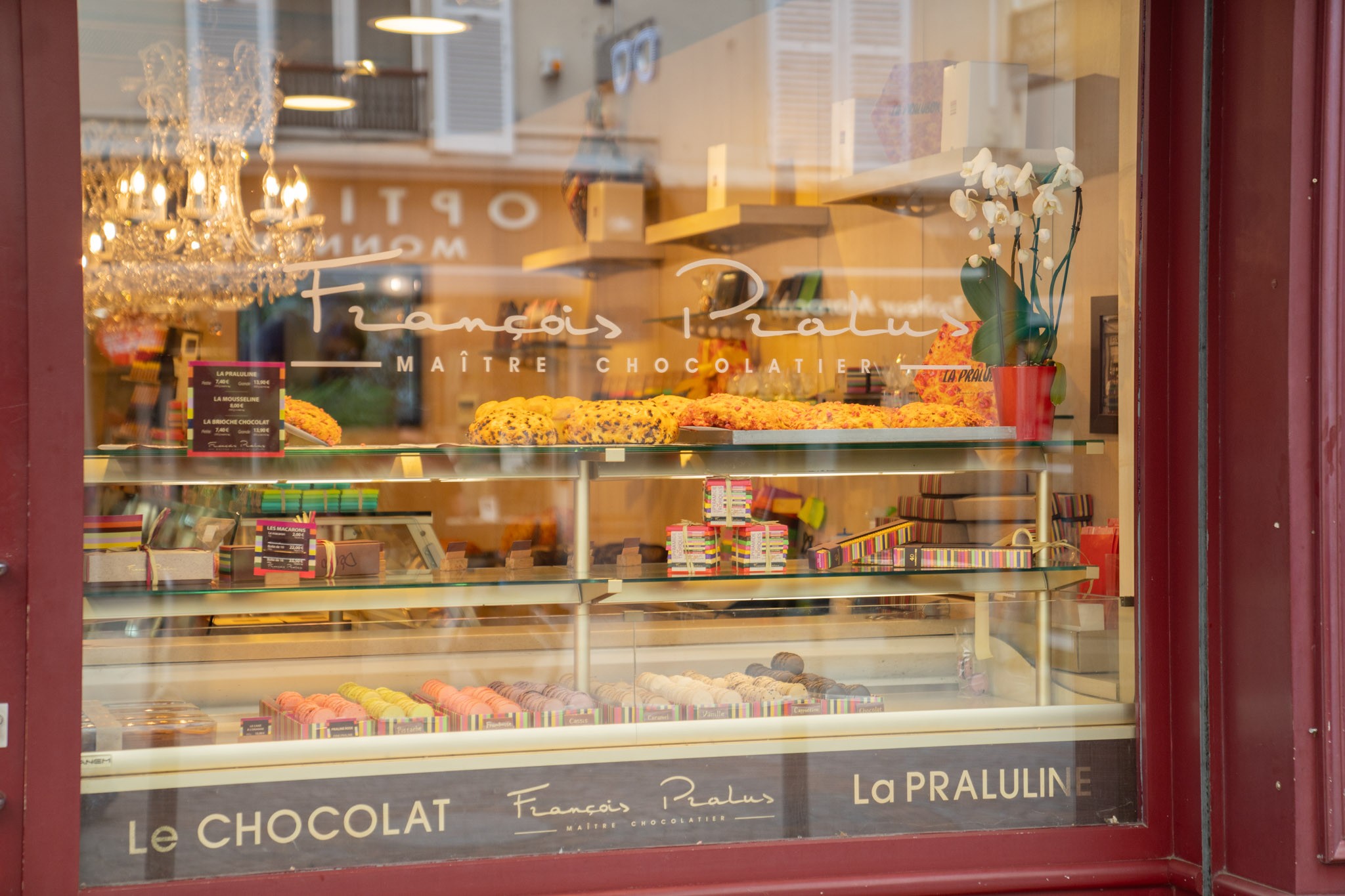 Vitrine parisienne éclairée chocolatier avec macarons et choclat